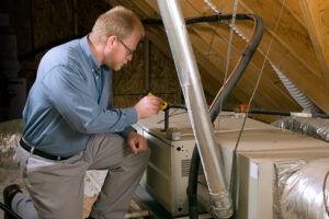 HVAC technician inspecting a furnace in the attic of an Aliquippa, PA home.