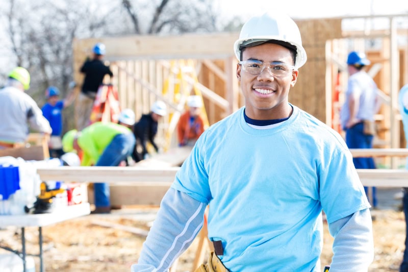 Schedule Your Annual Furnace Inspection Now. Photo of a construction or building contractor standing in front of a home that is being built.